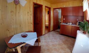 a kitchen with wooden walls and a table and a counter at Korondi Kulcsosházak in Corund