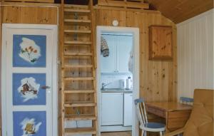 a kitchen and dining room with a spiral staircase in a tiny house at Nice Home In Staubø With House Sea View in Staubø