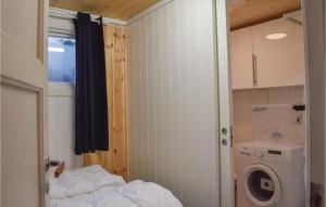 a small room with a bed and a washing machine at Amazing Home In Staub With 1 Bedrooms And Wifi in Staubø