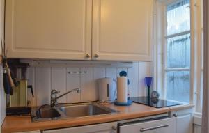 a kitchen counter with a sink and a window at Nice Home In Staubø With House Sea View in Staubø