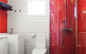 y baño con aseo y ducha con azulejos rojos. en Raaen Hytteutleige 3, en Utne