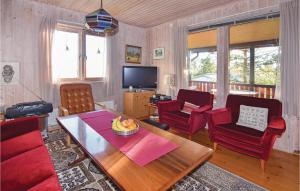 ストレムスタードにあるNice Home In Strmstad With 2 Bedroomsのリビングルーム(赤い椅子、テーブル付)