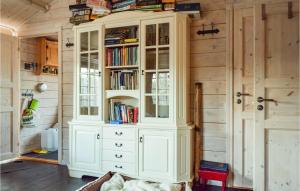 un grande armadio bianco con libri sopra in una stanza di 2 Bedroom Stunning Home In Kvinesdal a Kvinesdal