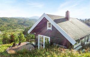 a house on a hill with two chairs on a deck at 5 Bedroom Cozy Home In Norheimsund in Norheimsund
