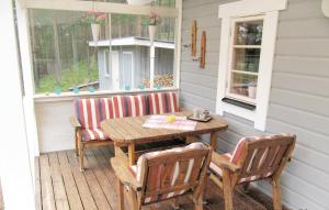 a wooden table and chairs on a porch at Beautiful Home In Hede With 3 Bedrooms And Sauna in Hedeviken