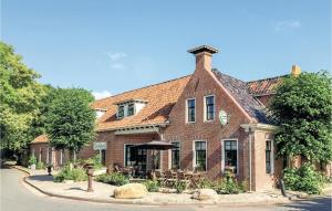 Cozy Home In Visvliet With Kitchen في Visvliet: مبنى من الطوب كبير به طاولات وكراسي أمامه