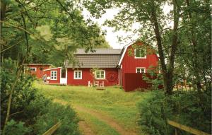 a red barn in the middle of a field at 3 Bedroom Awesome Home In Mårdaklev in Mårdaklev