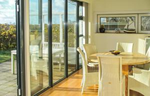 een eetkamer met glazen deuren en een tafel en stoelen bij Bellevue in Bergen aan Zee