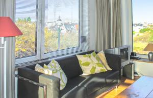 a living room with a black leather couch with yellow pillows at Bellevue in Bergen aan Zee