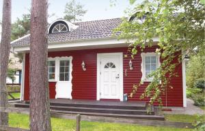 a red tiny house with a white door at 3 Bedroom Awesome Home In Degeberga in Degeberga