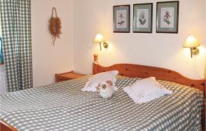 a dog sitting on a bed with two pillows at 3 Bedroom Awesome Home In Degeberga in Degeberga