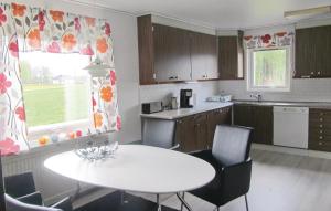 a kitchen with a white table and chairs at Stunning home in Bolms with 4 Bedrooms, Sauna and WiFi in Bolmsö