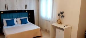 um quarto com uma cama com uma cabeceira azul e uma mesa em Villa Ginevra em Porto Cesareo