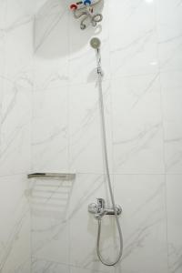 a shower with a shower head in a bathroom at Djuragan Kamar Griya Permata in Ngemplak