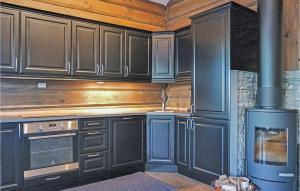 a kitchen with wooden cabinets and a stove at Sjusjøen Setegrend 4733 in Sjusjøen