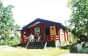 eine Gruppe von Personen, die auf der Veranda einer Hütte sitzen in der Unterkunft Gorgeous Home In Alingss With Sauna in Alingsås