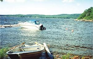 un bateau est amarré sur l'eau à côté d'une passerelle dans l'établissement Gorgeous Home In Alingss With Sauna, à Alingsås