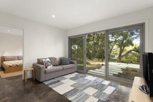 a living room with a couch and a sliding glass door at Bungoona in Apollo Bay