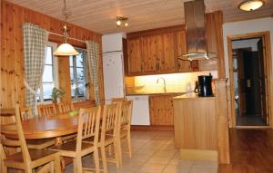 eine Küche und ein Esszimmer mit einem Holztisch und Stühlen in der Unterkunft 5 Bedroom Awesome Home In Segmon in Kangerud