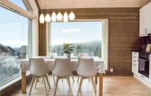 a dining room with a table and chairs and a large window at 3 Bedroom Beautiful Home In Sjusjen in Sjusjøen