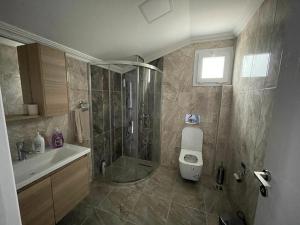 a bathroom with a shower and a toilet and a sink at Kartal Gözü Konaklama tesisi in Rize