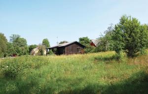 a field of grass with a barn in the background at 2 Bedroom Cozy Home In Hamneda in Hamneda