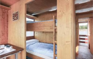 RadewegeにあるNice Ship-boat In Radewege With 2 Bedroomsの二段ベッド、デスク、テーブルが備わる木造キャビンです。
