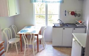 a kitchen with a table and chairs and a sink at Awesome Home In Odensvi With 2 Bedrooms in Stora Skälhem