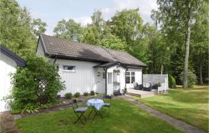 a white house with a table and chairs in the yard at Cozy Home In Hjo With Wifi in Hjo +19 photos