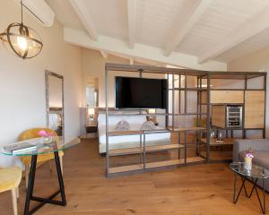 Sala de estar amplia con cama y TV en Podere Maremma Spa & Ristorante, en Orbetello