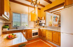 una cucina con mobili in legno e un frigorifero bianco di Lovely Home In Guillena With Wifi a Guillena