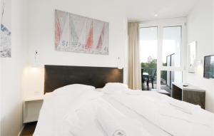 a white bedroom with a bed and a window at Highend Travemünde - Whg 212 in Travemünde