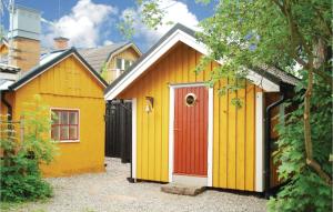 ein gelbes und orangefarbenes Haus mit einer roten Tür in der Unterkunft Lovely Home In Trosa With House Sea View in Trosa