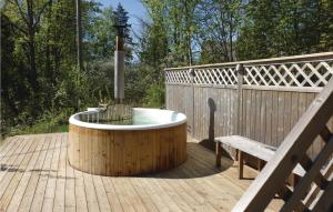 a hot tub on a wooden deck with a bench at Awesome home in Strngns with 2 Bedrooms and WiFi in Sundby