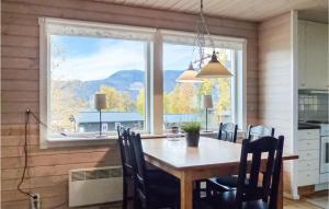 a dining room with a table and a large window at Cozy Home In Dikans With Kitchen in Kittelfjäll