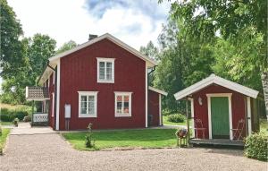 a red house with a green door in the yard at Amazing home in Unnaryd with 2 Bedrooms, Sauna and WiFi in Unnaryd