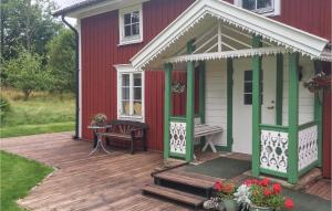 a red and white house with a wooden deck at 2 Bedroom Amazing Home In Unnaryd in Unnaryd