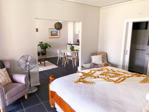 a bedroom with a bed and a chair and a table at Peacehaven Chalet on the Irwin Inlet in Bow Bridge