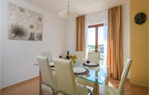 a dining room with a glass table and white chairs at Holiday Home Dobrani Cr in Rebići