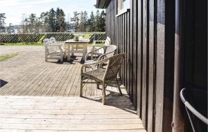 eine Terrasse mit 2 Stühlen und einem Tisch auf einem Gebäude in der Unterkunft Stunning Home In Enebakk With Kitchen in Omberg