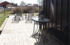 a patio with chairs and a table on a deck at Lovely Home In Enebakk With Wifi in Omberg +11 photos