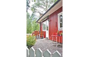 Czerwony dom z białym płotem obok niego w obiekcie 2 Bedroom Pet Friendly Home In rkelljunga w mieście Drakabygget