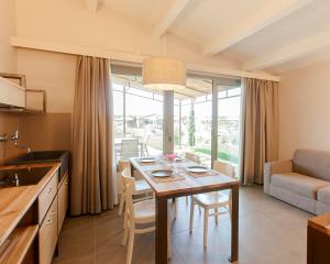cocina y sala de estar con mesa y sillas en Podere Maremma Spa & Ristorante, en Orbetello