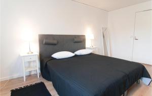 a bedroom with a black bed with two white pillows at Beautiful Apartment In Gotlands Tofta With 1 Bedrooms in Tofta