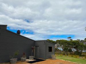 a house with a siding on the side of it at Peacehaven Chalet on the Irwin Inlet in Bow Bridge