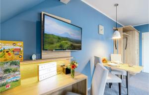 una sala da pranzo con TV su una parete blu di Beautiful Apartment In Dagebll With Kitchen a Dagebüll