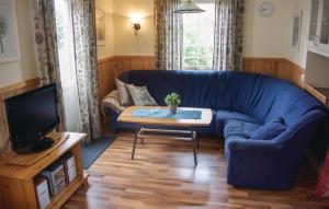 a living room with a blue couch and a table at Nice Home In Fjällbacka With Sauna in Fjällbacka