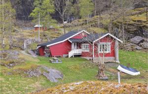 a red house with a boat in front of it at Beautiful Home In Nordtveitgrend in Haugen