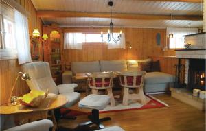 SjusjøenにあるNice Home In Sjusjen With House A Mountain Viewのリビングルーム(テーブル、椅子、ソファ付)