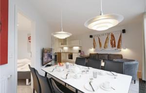 a dining room with a white table and chairs at Dünenvilla 4, Whg 4 in Travemünde